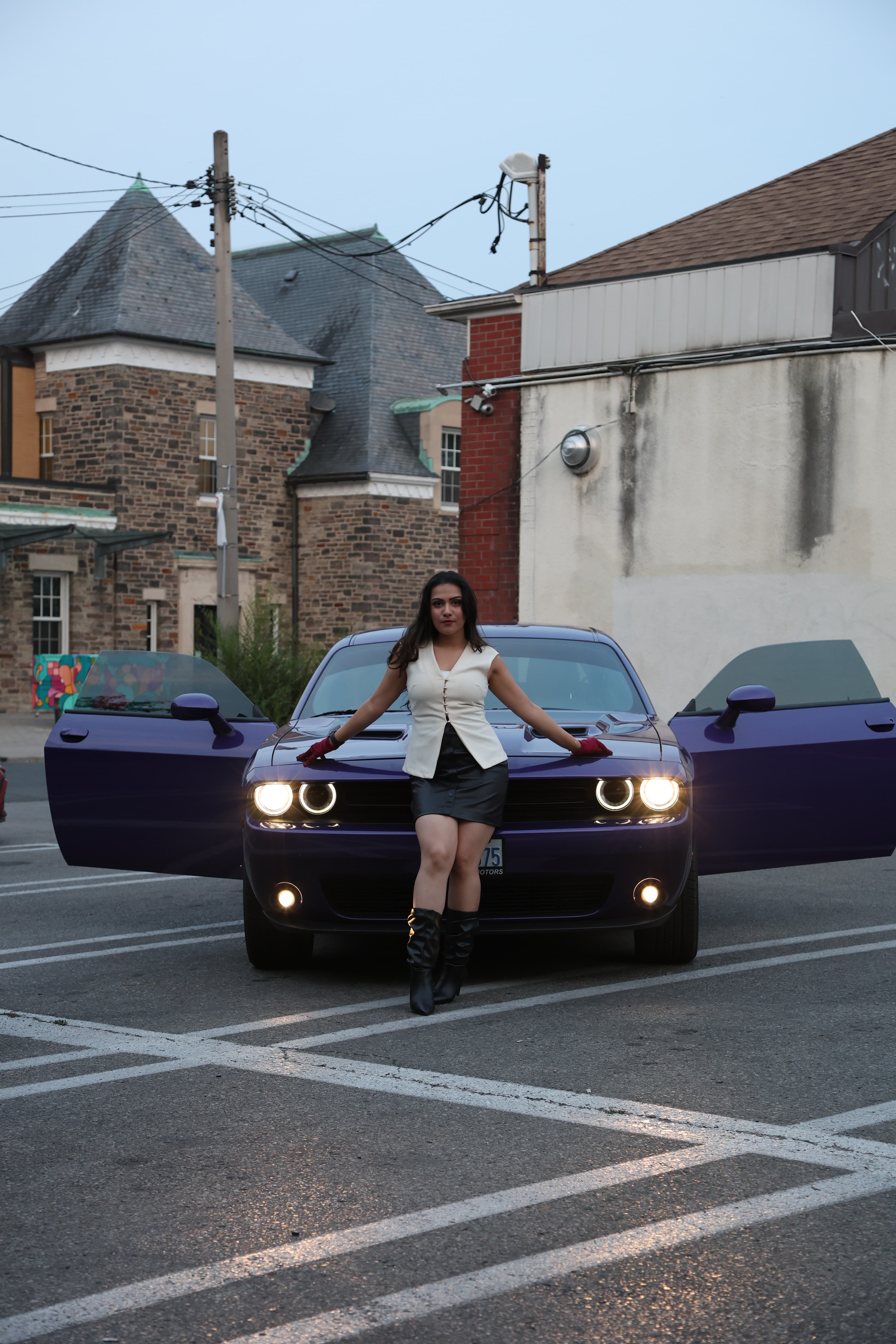 Woman posed with a purple Dodge Challenger